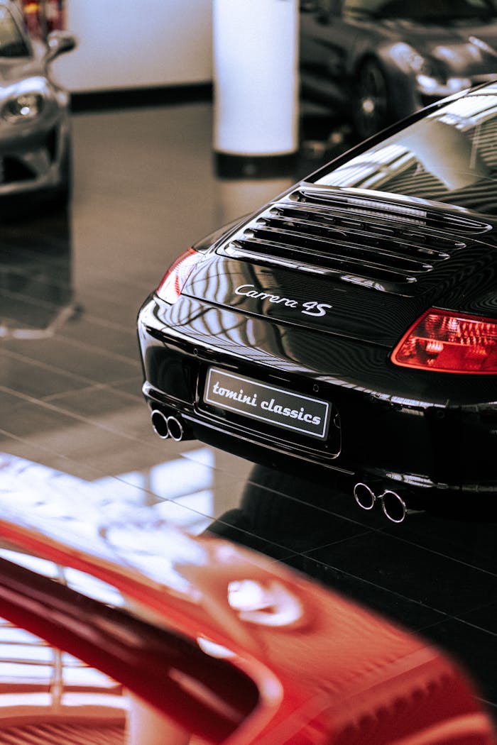 ours-journey Elegant black Porsche Carrera 4S showcased in a modern showroom setting, highlighting luxury and automotive design.