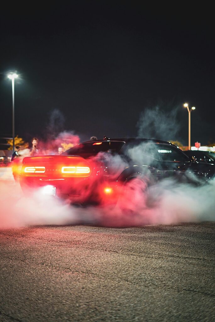 Seafoam Engine Treatment — Shockingly Simple Fix That Save $ A Dodge Challenger drifting with smoke at a nighttime car show.
